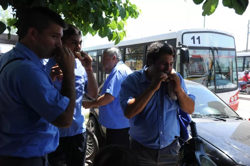 INCERTIDUMBRE. Los choferes, de paro, almuerzan en la sombra de un árbol hasta que se resuelva el conflicto.  la gaceta / Fotos de José Nuno