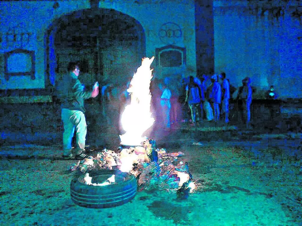 FUEGO EN LA CALLE. Ante la falta de información, los familiares encendieron neumáticos afuera. Los policías se plantaron con escopetas en las puertas.  