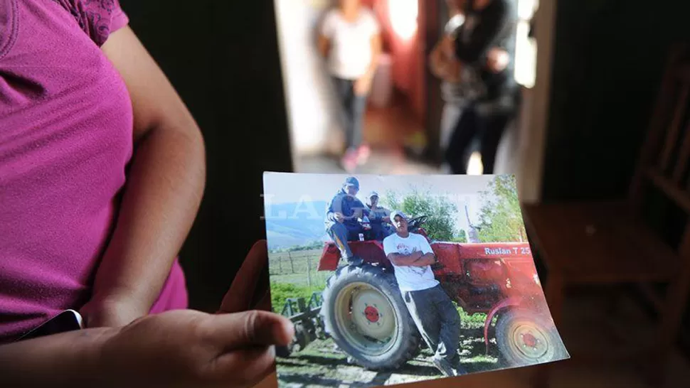 Una allegada a las víctimas muestra una foto en la que aparecen los dos fallecidos. LA GACETA / FRANCO VERA