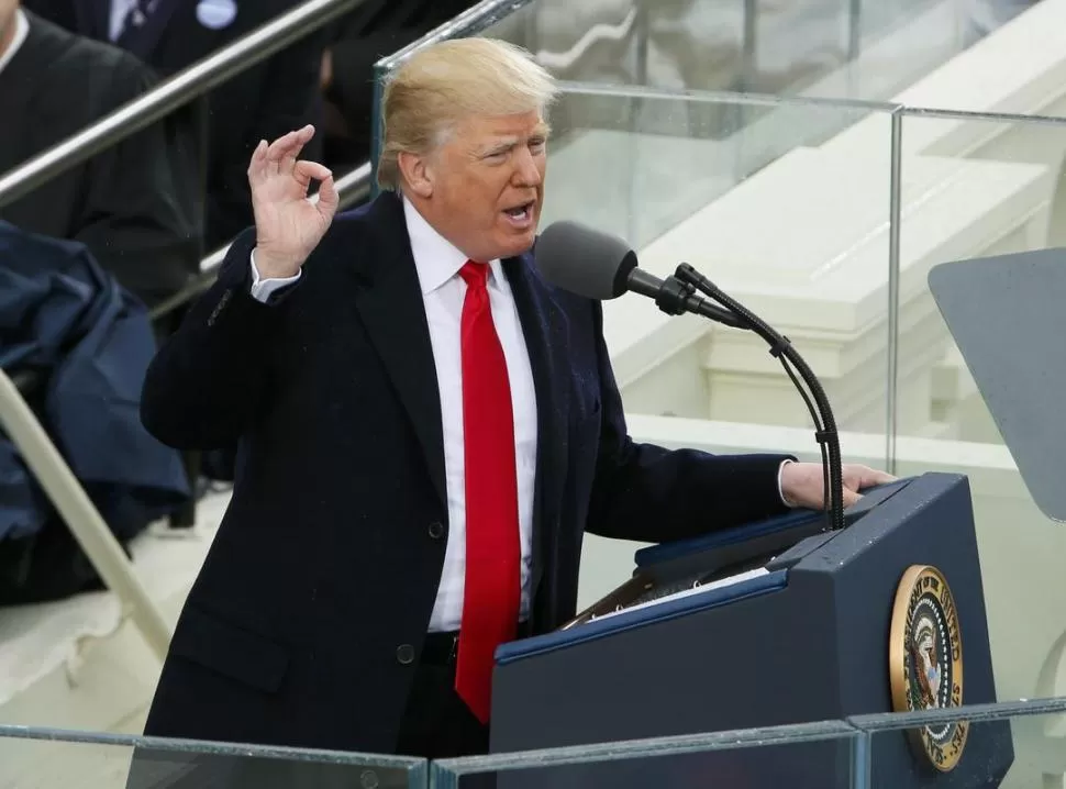 LLEGAN Y SE VAN. Trum conversa con Obama en las escaleras del Capitolio. Cerca de ellos, las primeras damas. REUTERS