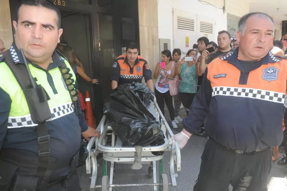 TAREAS POLICIALES. Personal de Bomberos traslada los restos del joven fallecido hacia la Morgue Judicial. la gaceta / fotos de Antonio Ferroni