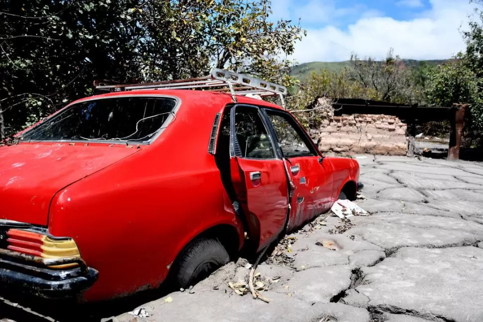 ENTERRADO. El propietario no pudo rescatar su auto, que quedó atrapado por el alud de barro y piedras que cayó del cerro a causa de la tormenta. fotos telam 