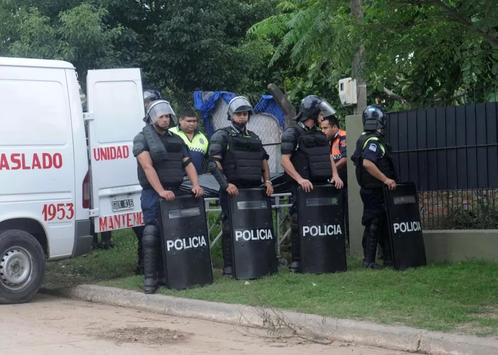 TRASLADO. Efectivos policiales custodian a bomberos que se llevan los restos. la gaceta / foto de Antonio Ferroni