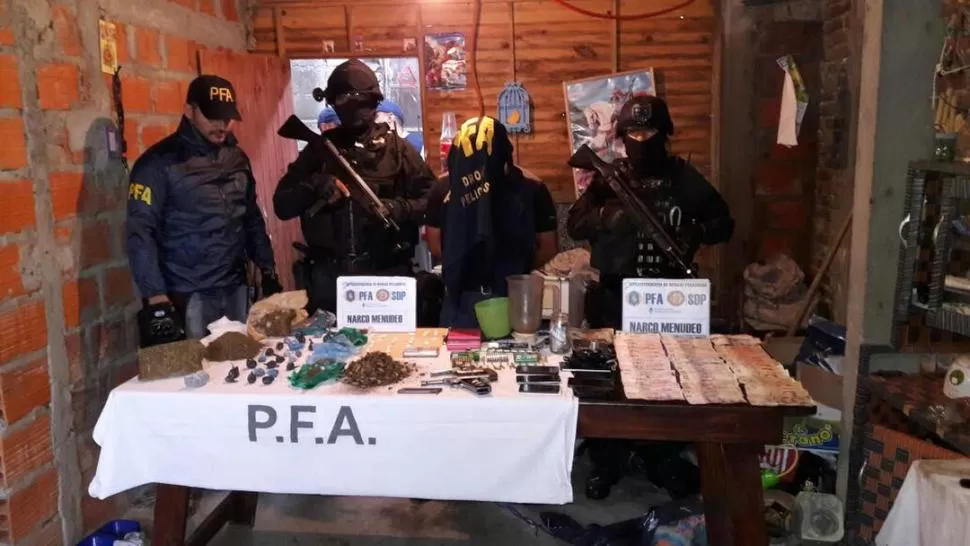 EXITOSO. El detenido con la droga, las armas y el dinero secuestrado. policía federal