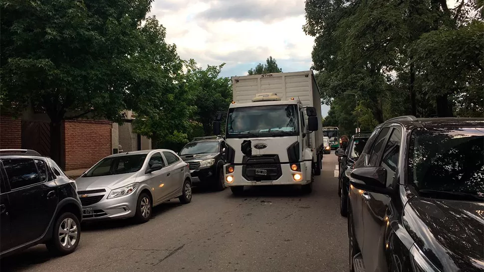 CAOS EN CIUDAD JARDÍN. Un camión recolector intenta avanzar entre dos filas de autos. FOTO GENTILEZA