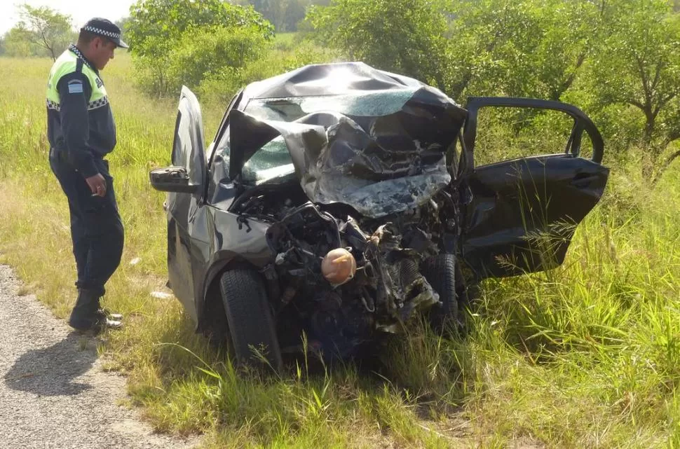 IRRECONOCIBLES. Un policía vigila los vehículos que quedaron destrozados a la vera de la ruta. la gaceta / fotos de osvaldo ripoll