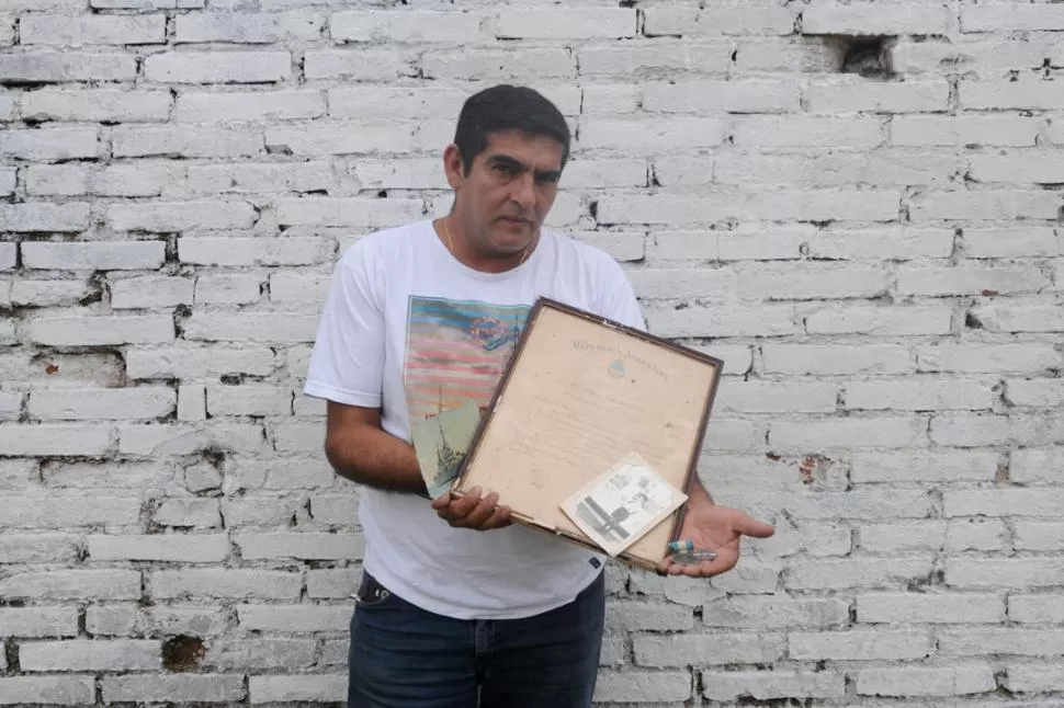 CUADROS, FOTOS, MEDALLAS. Todo cabe entre las manos de Rafael Palavecino, hermano de René Escobar. Derecha: el reverso de la postal del Belgrano, con la dedicatoria. la gaceta / fotos de analía jaramillo