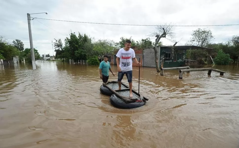 HUIR EN GOMONES IMPROVISADOS. En Graneros tuvieron que evacuar unas 300 personas que se ubicaron en dos escuelas; para salir por las calles anegadas del pueblo, algunos habitantes tuvieron que improvisar balsas. LA GACETA / FOTO DE OSVALDO RIPOLL 