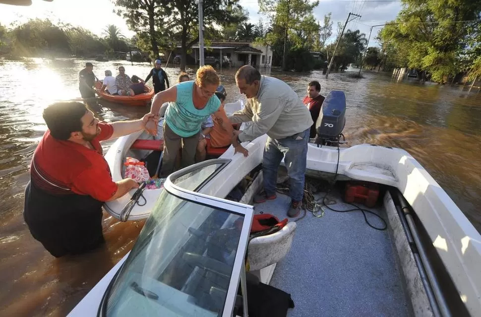 HUYENDO DEL TERROR. María Angélica Pérez y su esposo Enrique Brandán tuvieron que ser asistidos por particulares que pusieron sus lanchas a disposición para rescatar a las personas afectadas por la inundación LA GACETA / FOTO DE OSVALDO RIPOLL