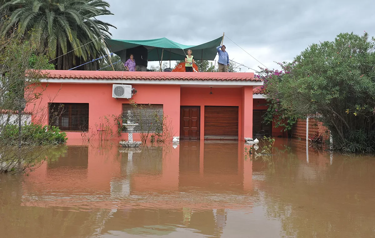 NO SE MARCHARÁN DE SU CASA. Instalados en el techo, los vecinos esperan que vuelva la normalidad. Pero pueden pasar varios días. LA GACETA/FOTO DE OSVALDO RIPOLL
