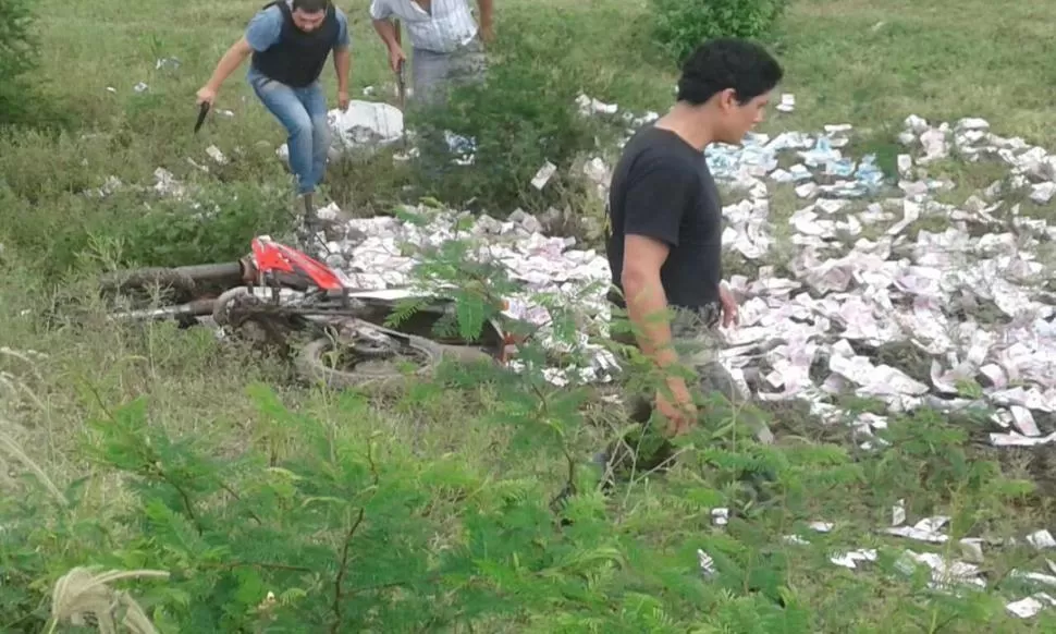 EN PLENA TAREA. Gendarmes y policías buscan evidencias en el campo donde quedaron esparcidos una importante cantidad de efectivo.  