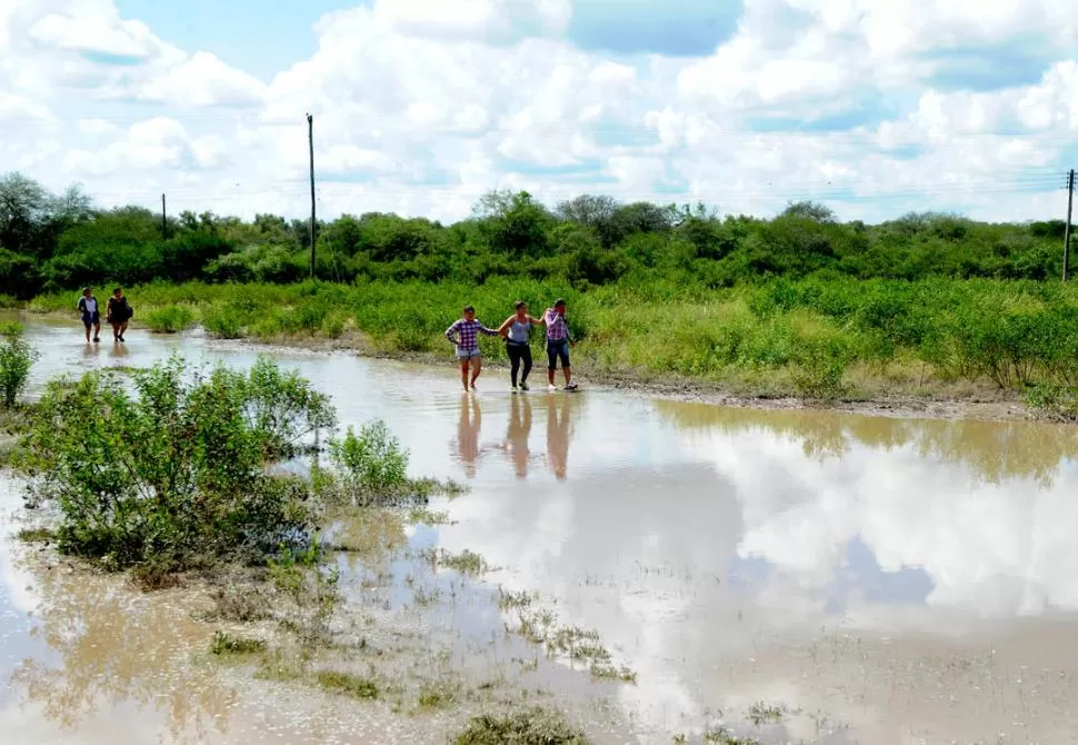 INUNDADO. Los vecinos del pueblo caminaron por el acceso en búsqueda de donaciones. En algunos puntos la huella quedó tapada por un metro de agua. la gaceta / fotos de franco vera 