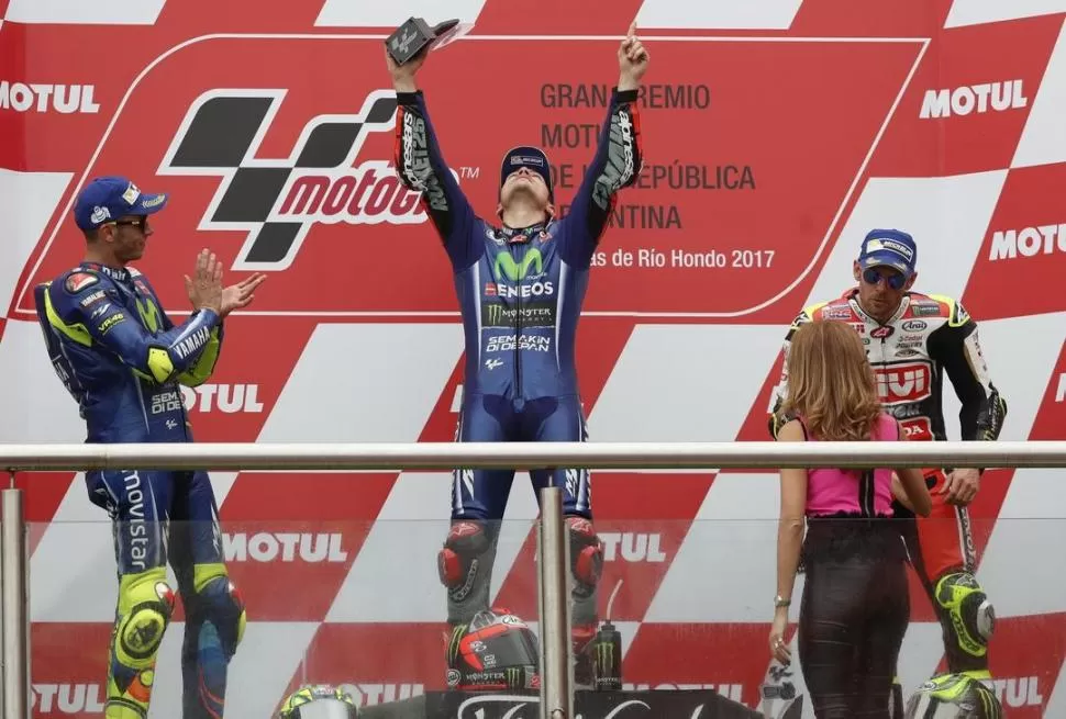 PODIO. Maverick Viñales celebra con sus brazos y mirada al cielo, mientras recibe el aplauso del ídolo Valentino Rossi; Cal Crutchlow completó el 1-2-3 en Las Termas. motogp