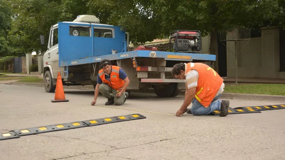 REDUCTORES DE VELOCIDAD. Dos operarios municipales trabajan en la calle. PRENSA MUNICIPALIDAD DE YERBA BUENA