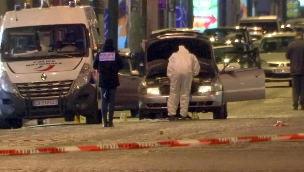 INVESTIGACIÓN. Los expertos en criminalística revisan el auto que utilizó el atacante de los policías. reuters