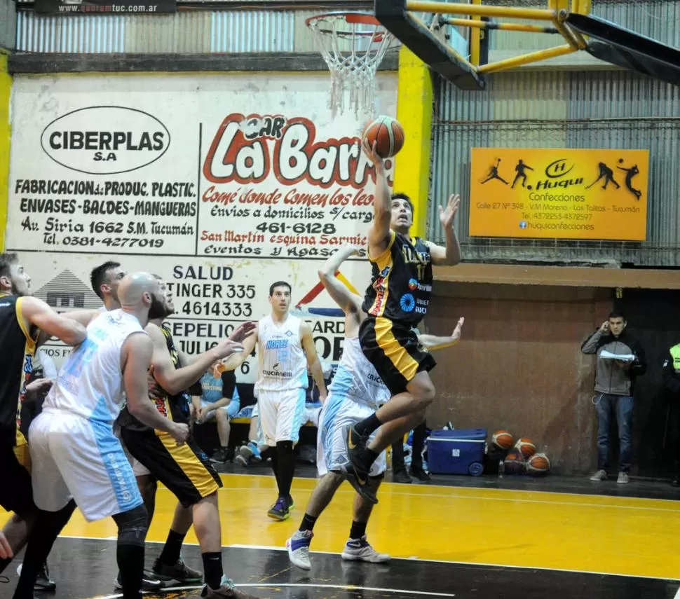 EN EL AIRE. El alero Cristian Soria busca el aro, con un santafesino al acecho. la gaceta / foto de hector peralta