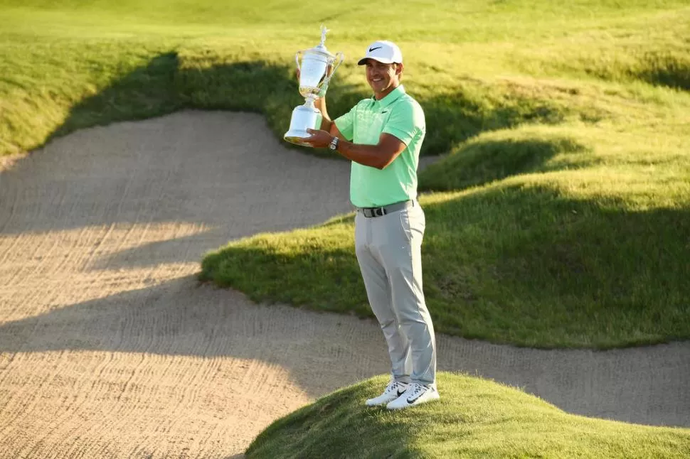 FELIZ. Koepka levanta su trofeo luego de una jornada que no podrá olvidar jamás.  reuters