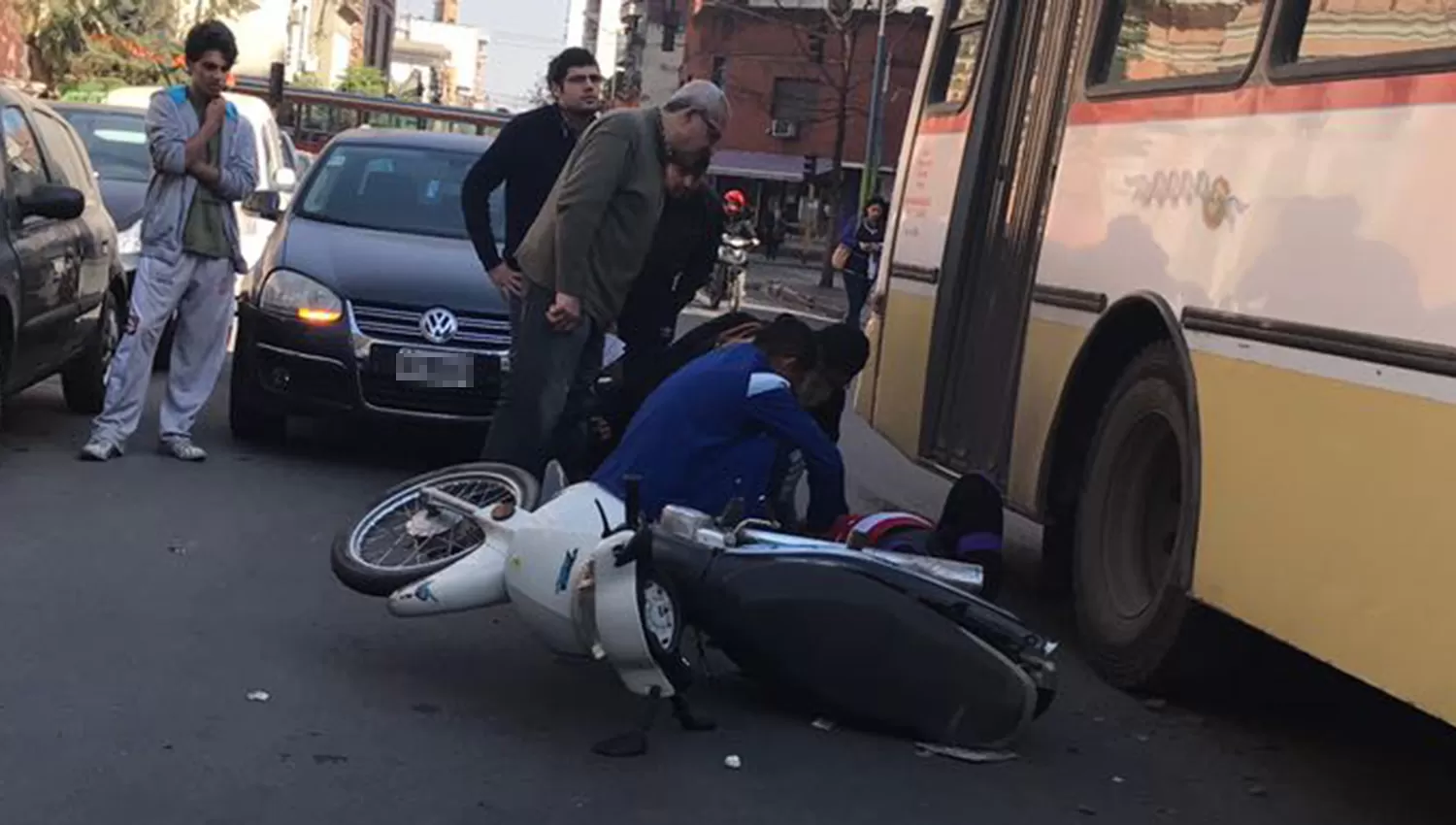 MUÑECAS AL 500. La mujer aparece en el suelo; en la imagen también se ve el colectivo y el auto. LA GACETA / JULIO MARENGO