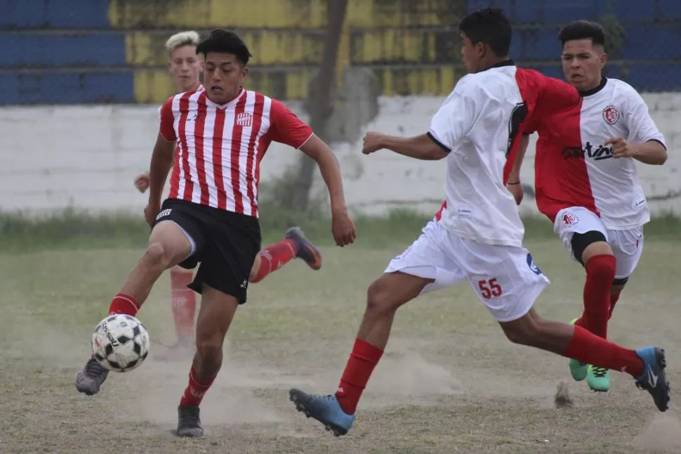 CLASE 2000. Juan Cruz Juárez, defensor de San Martín, trata de llevarse la pelota ante la marca de un jugador de Sportivo. foto de ALEJANDRO CRUZ