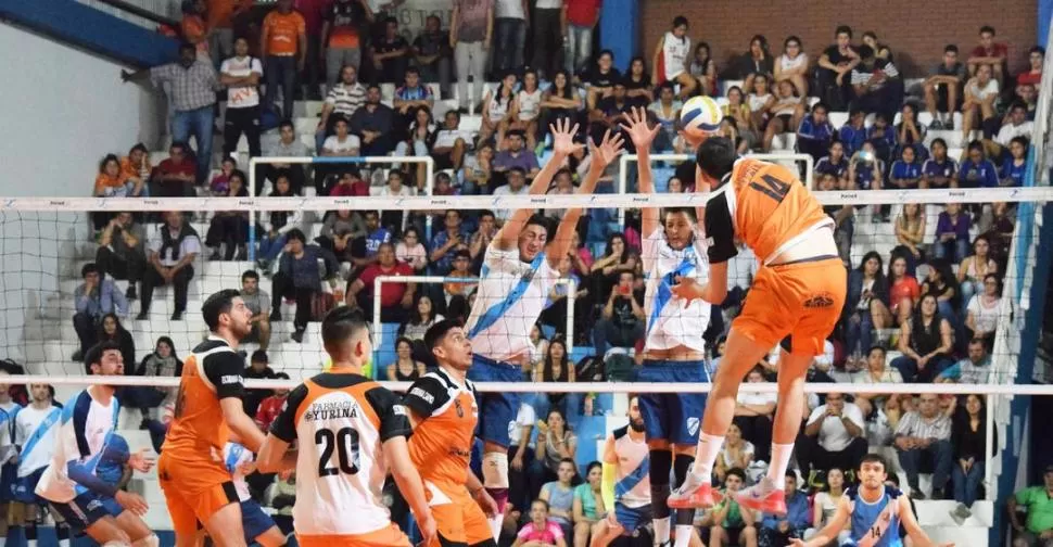 BUEN MARCO. Moreno, de Monteros Voley, ataca el bloqueo de Tucumán de Gimnasia, mientras la gente alienta en la tribuna. prensa monteros voley 