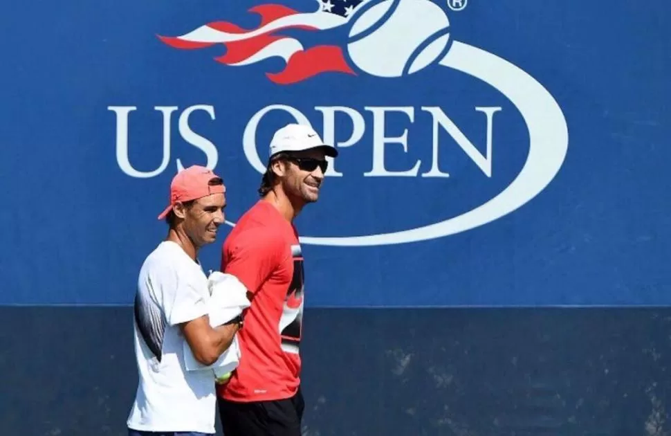 BUEN ANIMO. Nadal -de remera blanca- sonríe durante una práctica en Nueva York. Carlos Moyá, su entrenador, también.   twitter @RafaelNadal