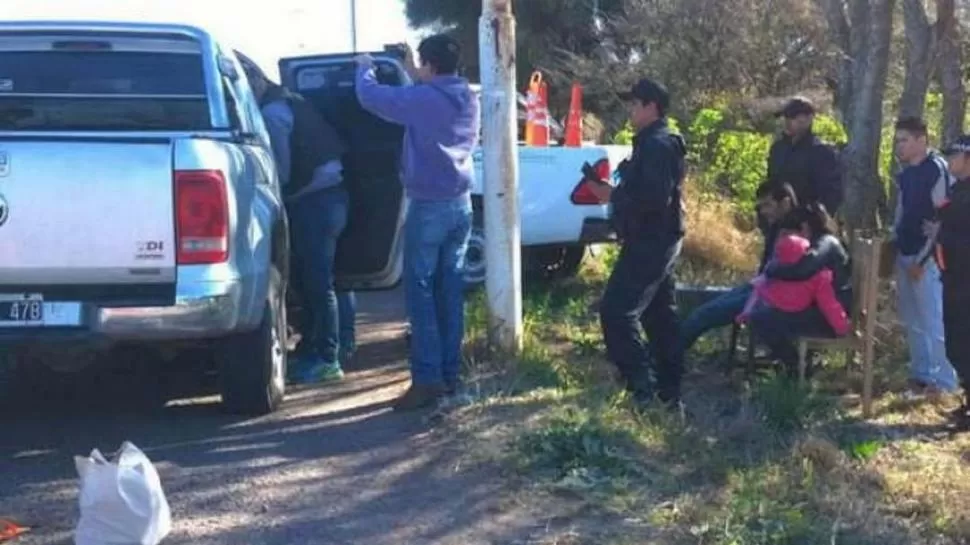 MOMENTO CLAVE. Los policías chaqueños revisan la camioneta. “Gastonero” observa la escena sentado en una silla y a la par está la mujer que lo acompañó. 