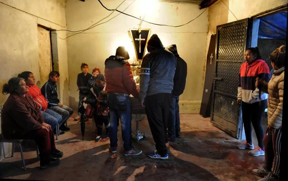 EL ADIÓS AL ADOLESCENTE. Familiares de “Huguito” lloran en el velatorio, en una casa de La Costanera. Sus amigos, junto al cajón, lo despiden. la gaceta / foto de antonio ferroni