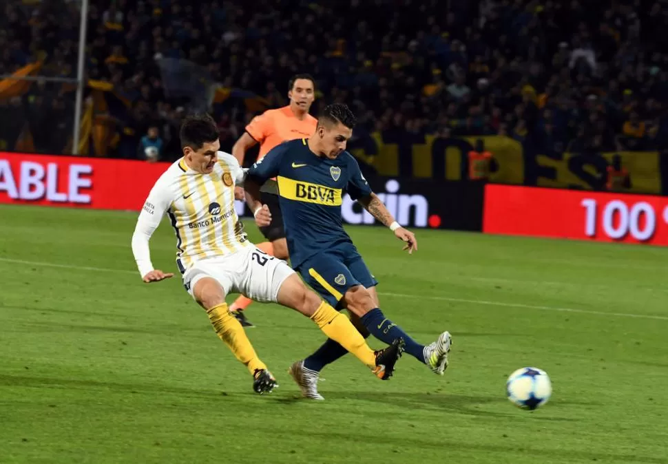 JUEGO MUY LUCHADO. José Leguizamón disputa la pelota con Cristian Pavón. El zaguero “canalla” estuvo muy firme; el delantero de Boca no tuvo una buena noche. fotos de telam