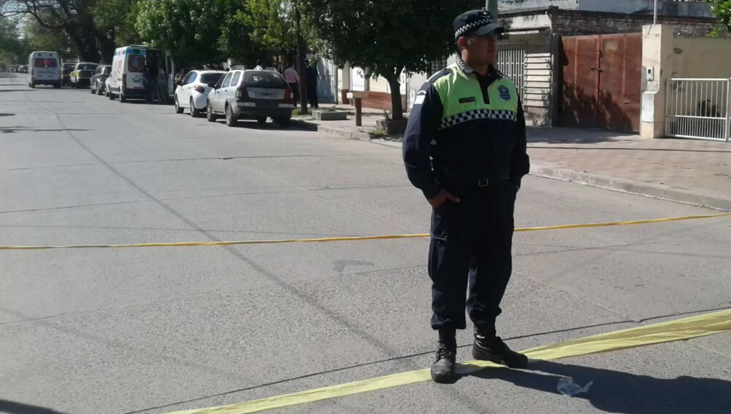 CUSTODIA. Un policía cuida la cuadra donde ocurrió el crimen. De fondo, las ambulancias. LA GACETA / FRANCO VERA