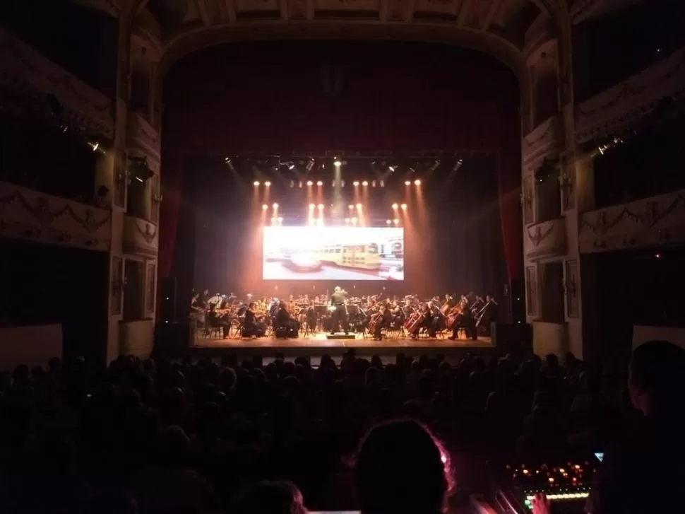 AVANT PREMIERE. La Sinfónica de la UNT, en acción, con la batuta de Roberto Buffo, mientras la pantalla proyecta imágenes inolvidables del cine.  