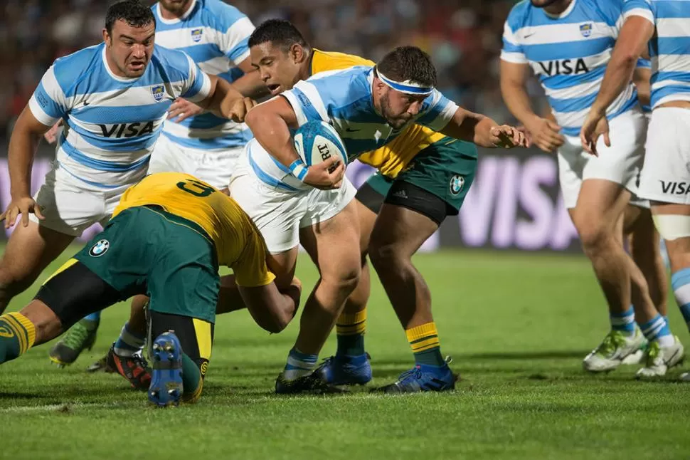 VA AL FRENTE. Lucas Noguera Paz avanza a pesar del tackle de Sekope Kepu. Los Pumas no pudieron sostener el ritmo. Dyn