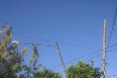 Un poste de la luz pende de un cable