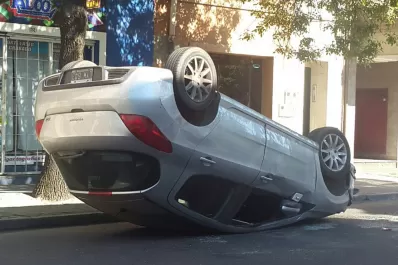 Perdió el control del auto, chocó una combi y quedó con las ruedas para arriba