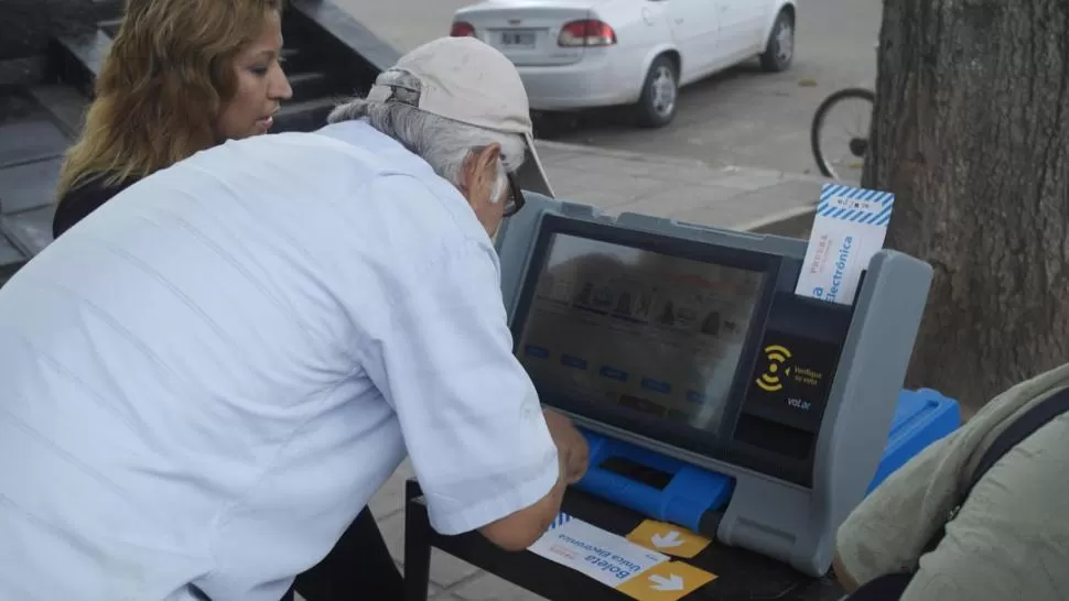 SALTA. Una capacitadora le explica a un elector el uso del voto electrónico. archivo