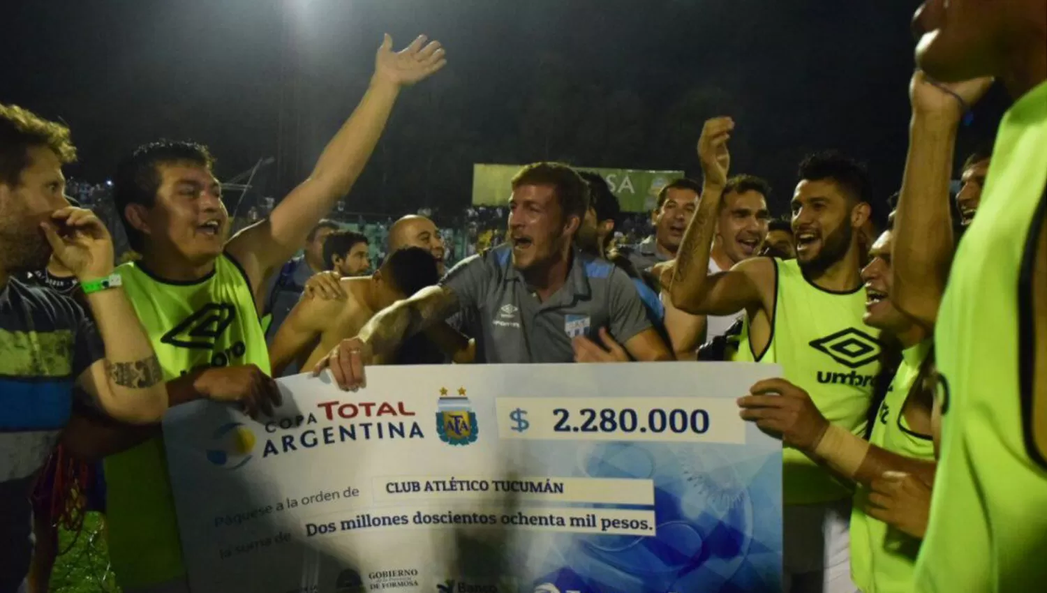 FELICES. El Pulguita, Sbuttoni y los demás jugadores de Atlético cantan junto al cheque. (ESPN)