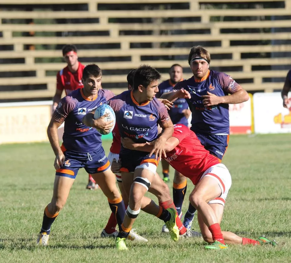 BUSCANDO LA DESCARGA. José Barros Sosa, apoyado por Matías Ferro y Nicolás Proto, trata de escapar al tackle de un rival. LA GACETA / FOTO DE hector peralta