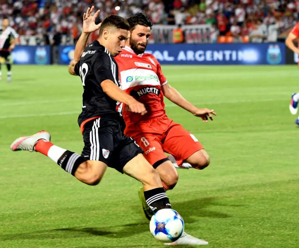 PELEANDO ARRIBA. Carlos Auzqui disputa la pelota con Lautaro Formica. River fue superior y defenderá el título ante Atlético. telam