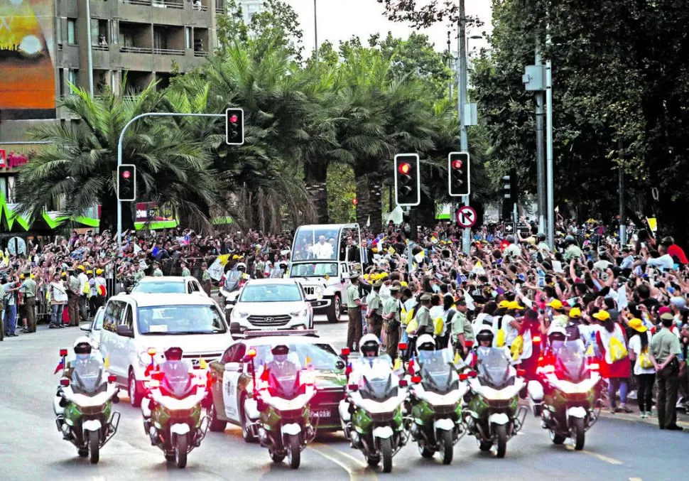 SALUDO DE LA MULTITUD. Subido al Papamóvil, Francisco recorrió las calles de Santiago en su traslado hacia la Nunciatura. A su paso, miles de fieles lo ovacionaron con banderas y carteles. 