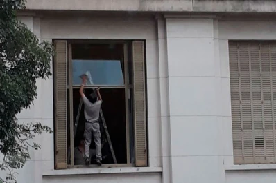 Sin protección y a varios metros de altura: así limpian los vidrios en Tribunales