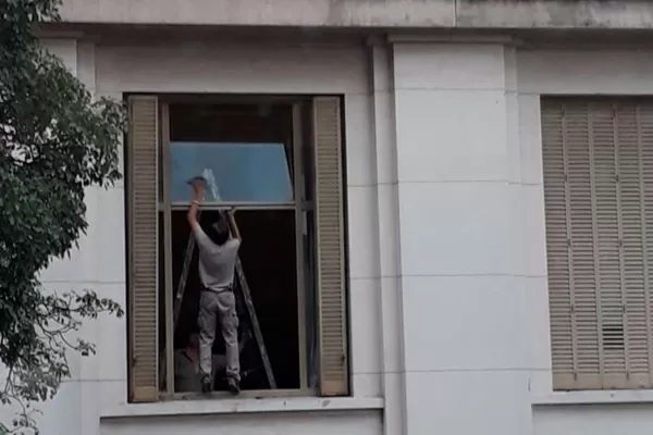 Sin protección y a varios metros de altura: así limpian los vidrios en Tribunales