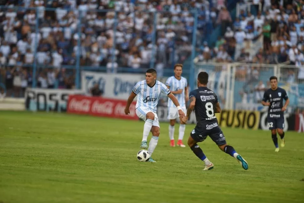 ATADA A SUS PIES. Barbona, que cerró la noche con un golazo, el del 3-0 para Atlético, domina el balón ante la llegada de Adrián Arregui, el único amonestado del juego. la gaceta / foto de diego aráoz