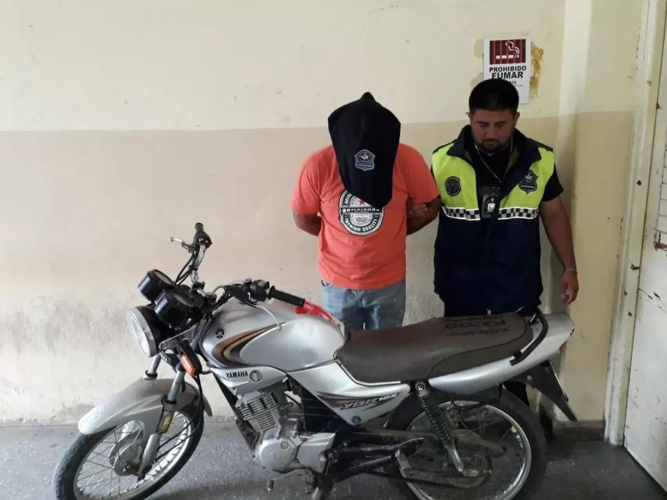 TRAS LAS REJAS. El detenido con la moto que habría sido utilizada.  