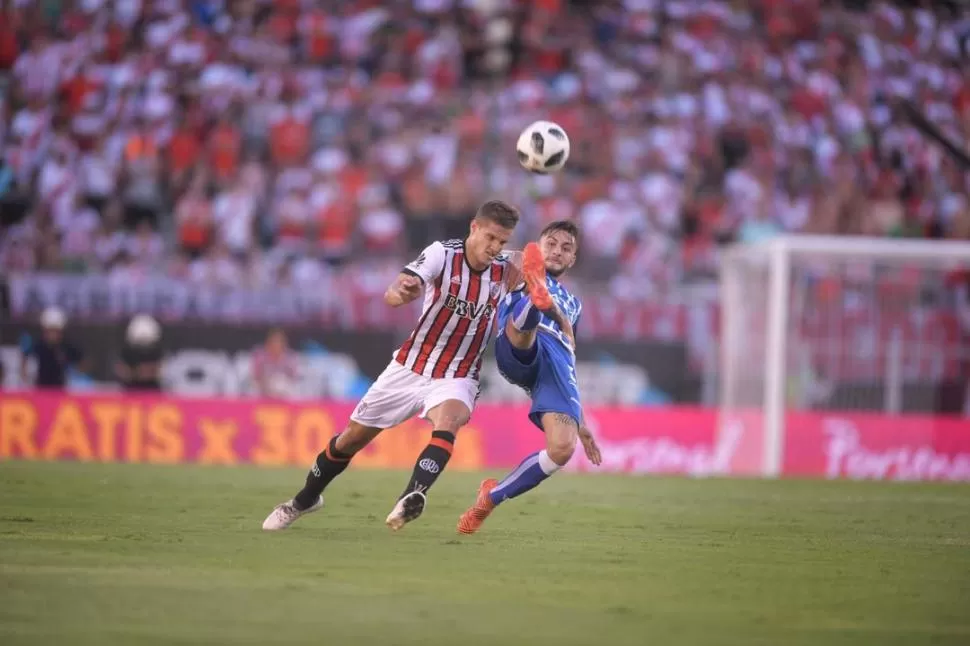 LUCHA EN LA MITAD DE LA CANCHA. Bruno Zuculini, de River, trata de superar la marca de Jalil Elías, del “Tomba”. telam 