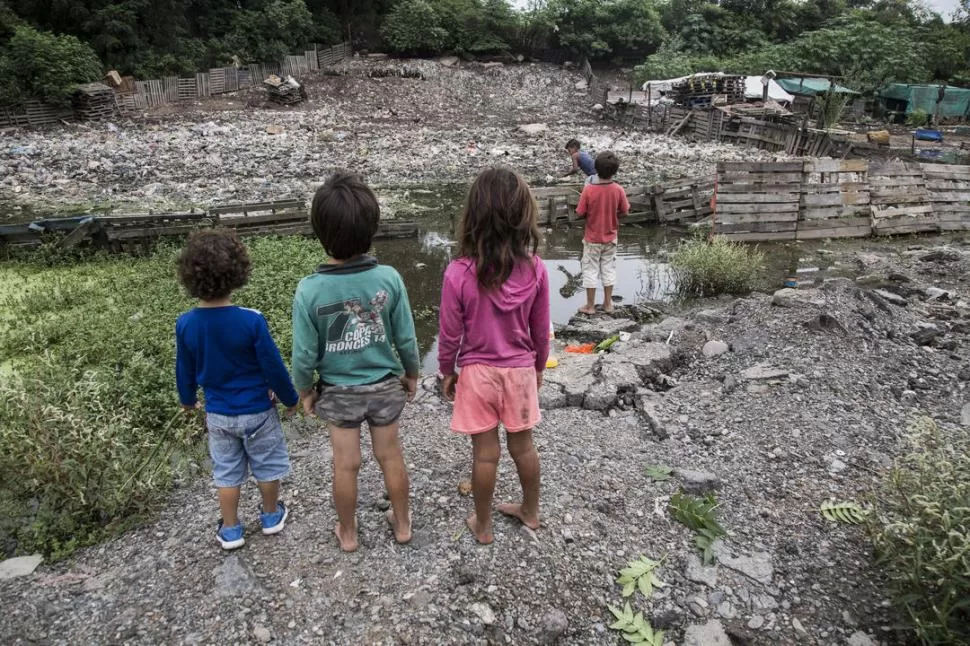 JUNTO AL AGUA ESTANCADA. Cinco niños juegan a la vera de la laguna de Los Vázquez, contaminada por los basurales que crecen alrededor. la gaceta / foto de matías quintana 