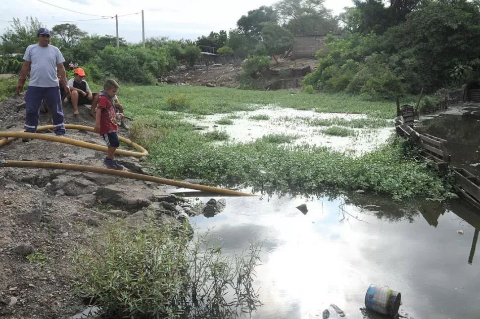 AGUA CON BASURA. La laguna, de unos 80 metros de largo por 30 de ancho, comenzó a ser desagotada ayer. la gaceta / foto de héctor peralta 