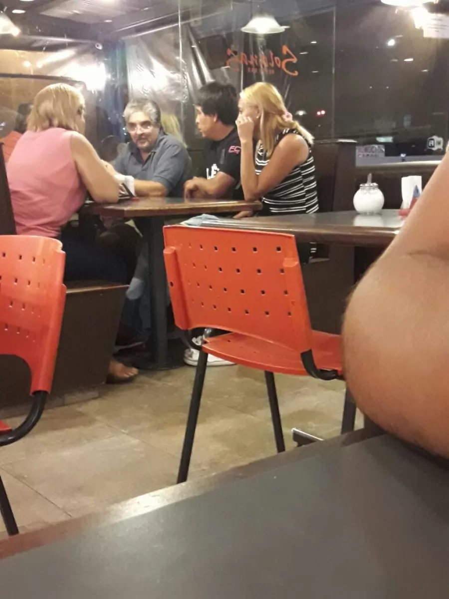 FOTOGRAFIADOS DESDE UNA MESA VECINA. Antonia Lobo (izquierda de espaldas), Juan Acosta y su esposa (de costado) dialogan con el agente del Instituto de la Vivienda y vendedor de casas, Daniel Manzaraz (de frente). 
