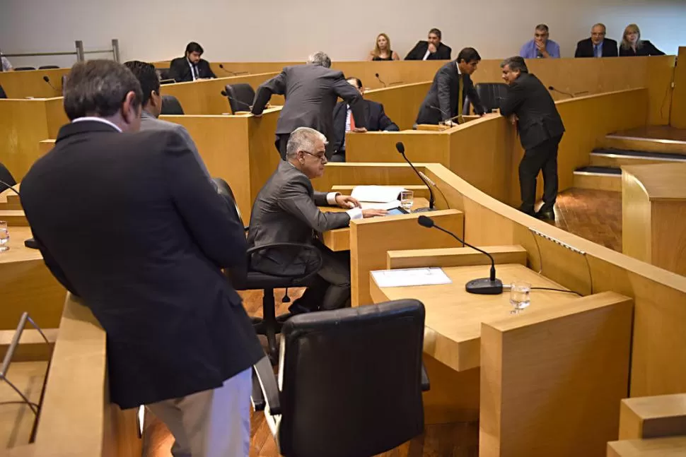 LOS PROTAGONISTAS. Loza (leyendo en su tablet) y “Johny” Ávila (al fondo, apoyado en su banca) permanecieron en el recinto durante el primer cuarto intermedio, dialogando con sus colegas de bancadas. la gaceta / foto de José Nuno