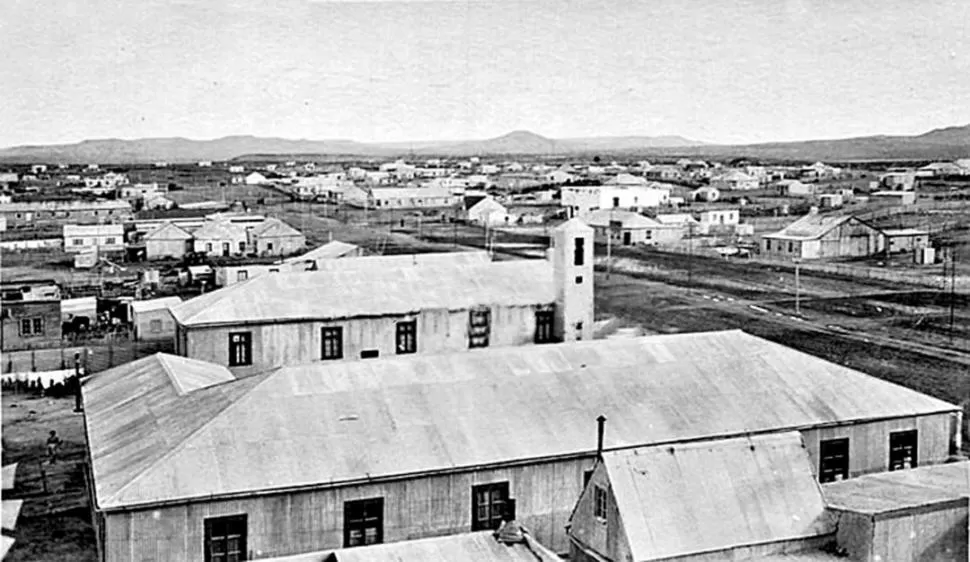 CASAS DESPERDIGADAS. Puerto San Julián, ubicado 350 kilómetros al norte de la capital provincial, Río Gallegos, estaba poblado de viviendas bajas mientras delante puede verse la pequeña capilla católica. Las calles eran de tierra.