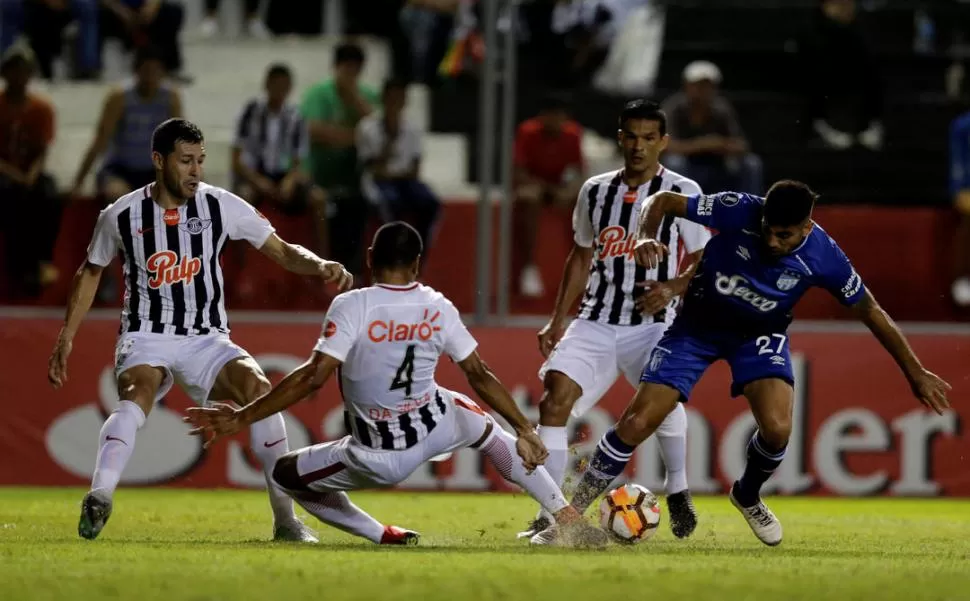 PARTIDO TRABADO. Leandro Díaz trata de llevarse la pelota ante la marca de tres jugadores de Libertad. Esta vez, el delantero del “Decano” casi no entró en juego, porque no lo asistieron. reuters