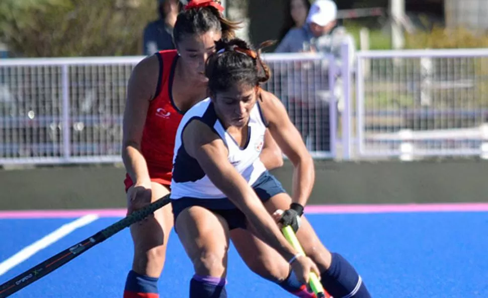 PRESIÓN. Abril López trata de cubrir la bocha ante la marca de una rival. confederación argentina de hockey